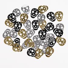 Close-up of Mexican sugar skull confetti faces in gold, silver and black