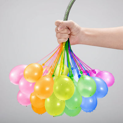Hand holding a bunch of colorful balloons against a black background
